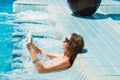 Technology and vacation concept. Luxury travel. Young pretty woman using tablet computer while relaxing in spa jacuzzi.