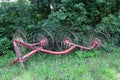 Abandoned antique hay tedder (hay tedder) and no longer in use. Probably here for decoration.