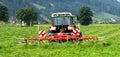 Tedding hay with tractor. Rear view of a tractor with hay tedder