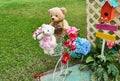 Teddy bares are put near colorful faked flowers.