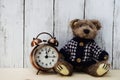 Teddy bear and alarm clock with space copy on wooden background Royalty Free Stock Photo