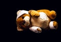 Teddy bear bandaged with bandages and band-aid, lying on the floor, concept of child abuse or violence, image representing