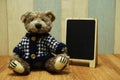 Teddy bear and blackboard easel wooden space background Royalty Free Stock Photo