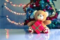 Teddy Bear in Christmas and Multi colored balls on christmas tree Royalty Free Stock Photo