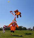 Teddy Bear and Clown Kites airborne blue sky grass and trees