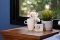 A teddy bear,coffee cup and white alarm on wood table in blue bedroom Royalty Free Stock Photo