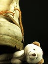 Teddy bear crushed by a heavy, old military boot.