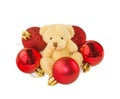 Teddy bear with five red Christmas balls on white.