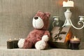 Teddy bear and gift box with candles on sack background Royalty Free Stock Photo