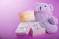 Teddy bear with a gift box for Valentines day on purple background Royalty Free Stock Photo