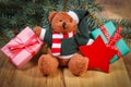 Teddy bear with gifts for Christmas, spruce branches and red star Royalty Free Stock Photo