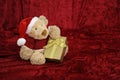 Teddy bear with golden gift box on red Royalty Free Stock Photo