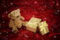 Teddy bear with golden gift box on red Royalty Free Stock Photo