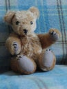 Teddy bear handmade sitting on blue rug.