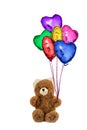 Teddy bear holding colorful heart shaped balloons. Royalty Free Stock Photo