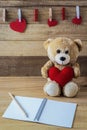 Teddy bear holding a heart-shaped pillow