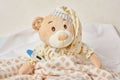 Teddy bear lying sick in bed with with thermometer Royalty Free Stock Photo