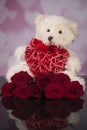 Teddy bear mascot and red roses and red wicker heart for valentine`s day