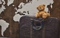 Teddy bear on an old leather suitcase on a wooden background Royalty Free Stock Photo