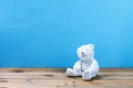 Teddy bear on old wood ,blue wall background. Royalty Free Stock Photo
