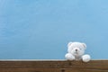 Teddy bear on old wood and blue wall background. Royalty Free Stock Photo