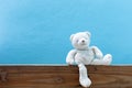 Teddy bear on old wood in front blue wall background. Royalty Free Stock Photo