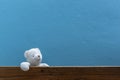 Teddy bear on old wood in front blue wall background Royalty Free Stock Photo