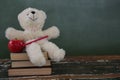 Teddy bear, pencil and apple on stack of books Royalty Free Stock Photo