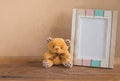 Teddy bear and photo frame on wooden background Royalty Free Stock Photo