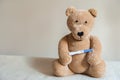 Teddy bear and positive pregnancy test close up and copy space. Children`s toy bear, booties, test