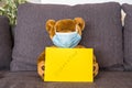 Teddy bear with a protectiv medical mask and paper with inscription Quarantine