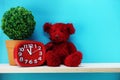 Teddy bear and red alarm clock with space copy on wooden background Royalty Free Stock Photo