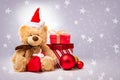 Teddy bear in a red cap and boxes with gifts on a background with stars Royalty Free Stock Photo