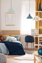 Teddy bear on single wooden bed in blue and orange bedroom interior Royalty Free Stock Photo