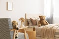 Teddy bear on single wooden bed in natural kid`s bedroom Royalty Free Stock Photo