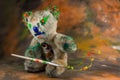 Teddy bear sits and make magic with bursting paint Royalty Free Stock Photo