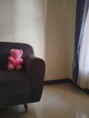 The teddy bear is sitting alone waiting in the living room