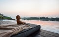 Teddy bear sitting look through the river on sunrise