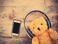 Teddy bear with smiling happy face in headphone and mobilephone Royalty Free Stock Photo