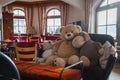 Teddy bear with stuffed toys arranged on sofa inside luxurious hotel