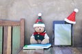 Teddy bear with tablet and santa hat on table Royalty Free Stock Photo