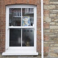 A teddy bear and thank you sign in a house window