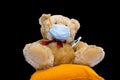 Brown teddy bear in medical mask with thermometer. coronavirus, covid 19 protection concept. quarantine and child safety problem Royalty Free Stock Photo