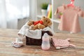 Teddy bear toy in basket with baby things on table