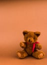 Teddy bear toy on a brown background with copy space