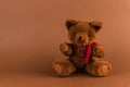 Teddy bear toy on a brown background with copy space