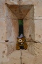 Teddy bear toy perched on an arrowslit or loophole castle window