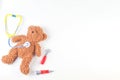 Teddy bear with toy stethoscope and toy medicine tools on a white background. Top view Royalty Free Stock Photo