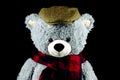 Toy Teddy Bear Wearing Tweed Cap and Tartan Scarf on a Black Background