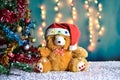 Teddy Bear wear hat in Christmas and Multi colored balls on christmas tree Royalty Free Stock Photo